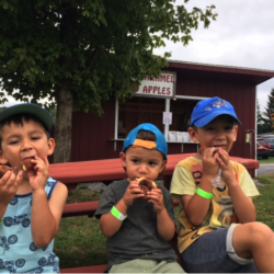 Fall Festivals – Past and Present Adorable kids eating apple cider donuts