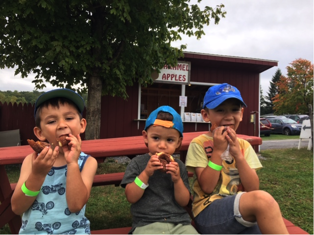 Adorable kids eating apple cider donuts