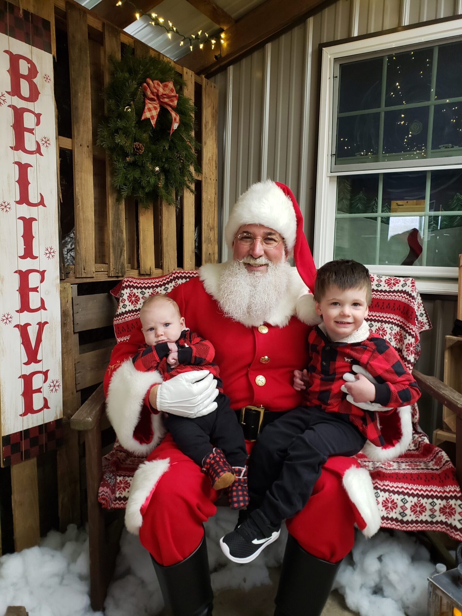 two boys sitting on santa's lap